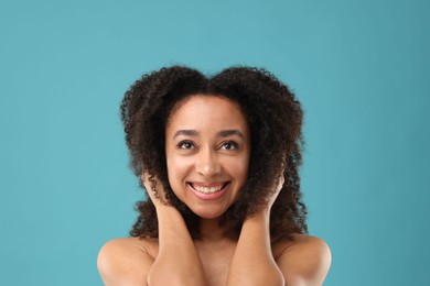 Photo of Portrait of beautiful Brazilian woman after spa treatment on light blue background