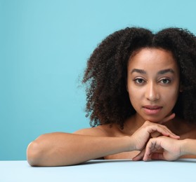 Photo of Portrait of beautiful Brazilian woman after spa treatment on light blue background
