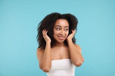 Photo of Portrait of beautiful Brazilian woman after spa treatment on light blue background