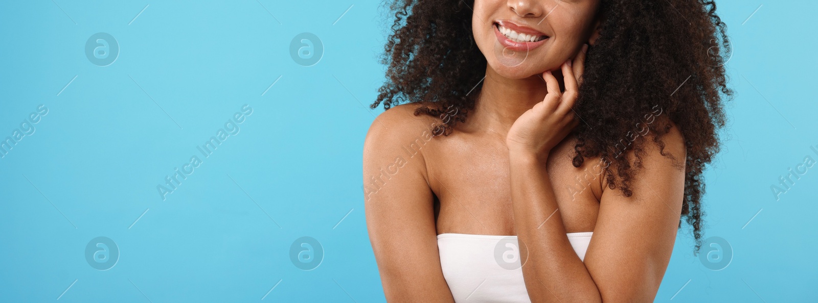 Brazilian woman after spa treatment on light blue background, closeup. Space for text Photo of Brazilian woman after spa treatment on light blue background, closeup. Space for text