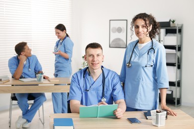 Photo of Medical students in uniforms studying together at university
