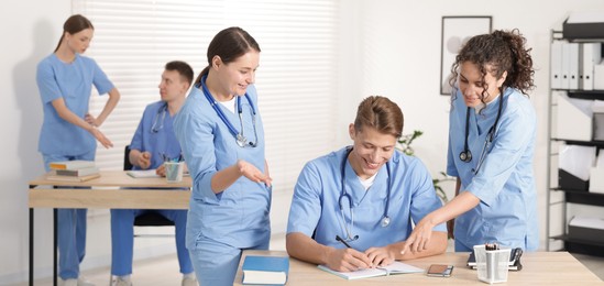 Photo of Medical students in uniforms studying together at university