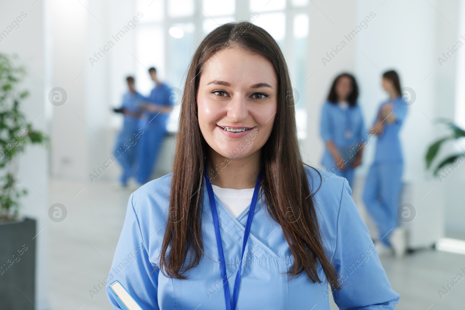 Medical student in uniform with notebook indoors, selective focus Photo of Medical student in uniform with notebook indoors, selective focus