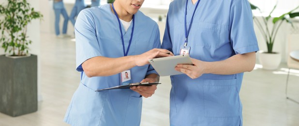 Photo of Medical students in uniforms studying together indoors, selective focus