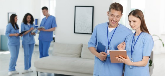 Photo of Medical students in uniforms indoors, selective focus