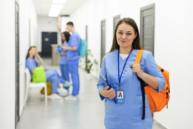 Photo of Medical student in uniform with backpack at university, selective focus