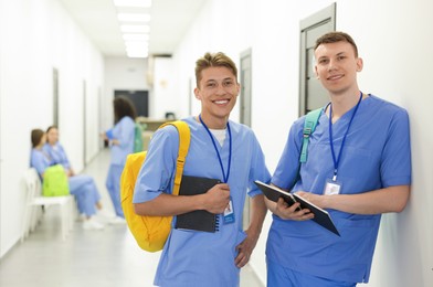 Photo of Medical student in uniforms with backpacks and notebooks at university, selective focus