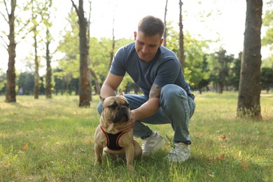 Photo of Happy man with his cute French bulldog in park