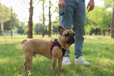 Photo of Man with his cute French bulldog in park, closeup