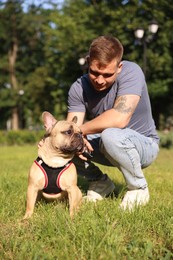 Photo of Happy man with his cute French bulldog in park