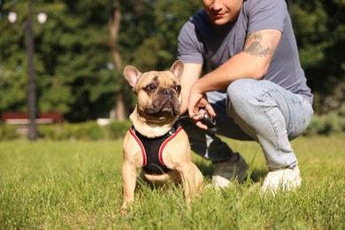 Photo of Man with his cute French bulldog in park, closeup
