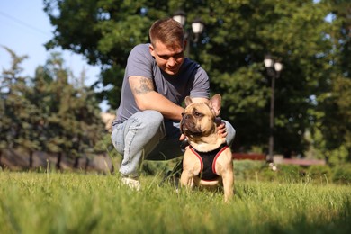 Photo of Happy man with his cute French bulldog in park