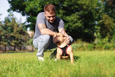 Photo of Happy man with his cute French bulldog in park