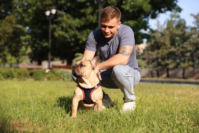 Photo of Happy man with his cute French bulldog in park
