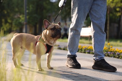 Photo of Man with his cute French bulldog in park, closeup
