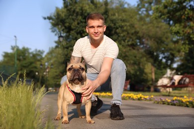 Photo of Happy man with his cute French bulldog in park