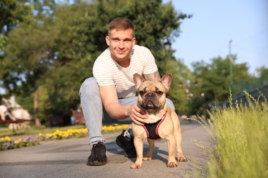 Photo of Happy man with his cute French bulldog in park