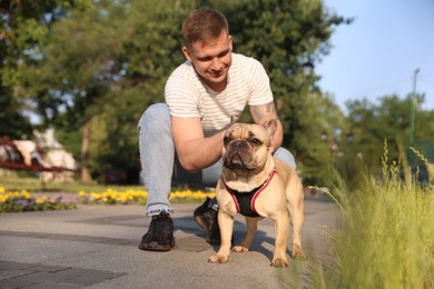 Photo of Happy man with his cute French bulldog in park