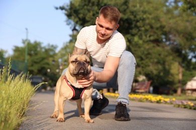 Photo of Happy man with his cute French bulldog in park