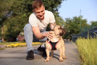 Photo of Happy man with his cute French bulldog in park