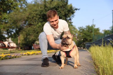 Photo of Happy man with his cute French bulldog in park