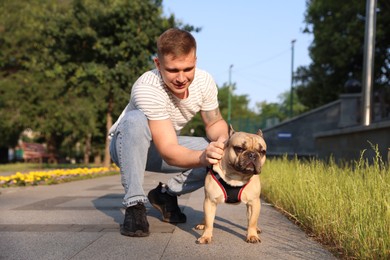 Photo of Happy man with his cute French bulldog in park