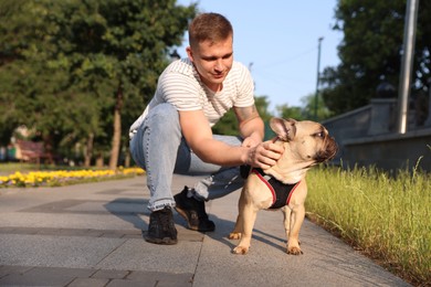 Photo of Happy man with his cute French bulldog in park