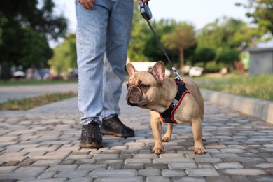 Photo of Man with his cute French bulldog in park, closeup