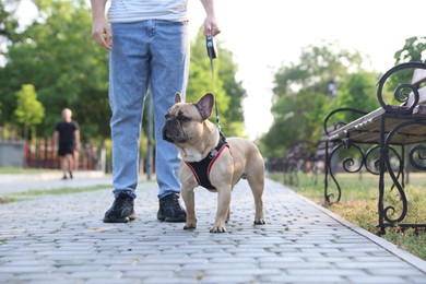 Photo of Man with his cute French bulldog in park, closeup