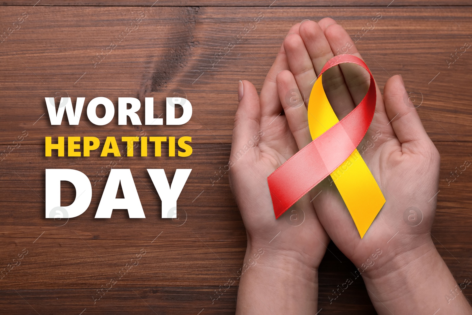 28th july World Hepatitis Day. Woman holding yellow-red awareness ribbon on wooden background, top view Image of 28th july World Hepatitis Day. Woman holding yellow-red awareness ribbon on wooden background, top view