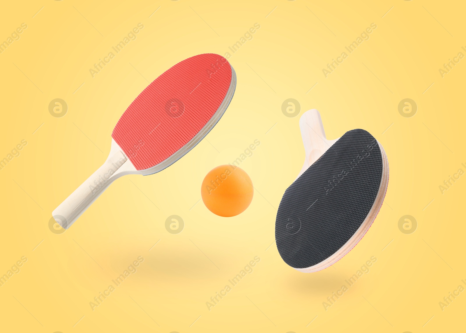 Ping pong rackets and ball in air against pale orange background Image of Ping pong rackets and ball in air against pale orange background