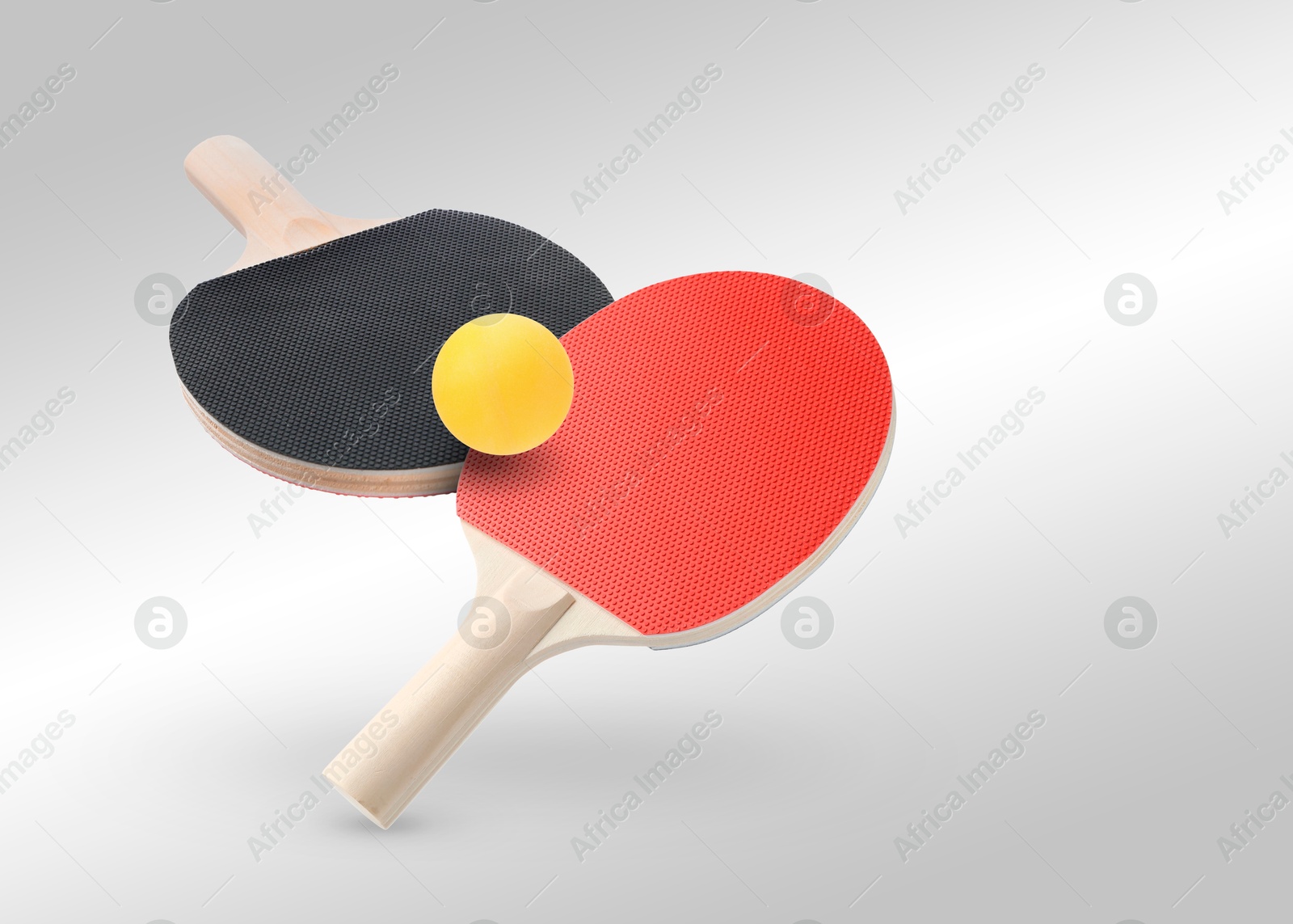 Ping pong rackets and ball in air against light grey background Image of Ping pong rackets and ball in air against light grey background