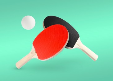 Image of Ping pong rackets and ball in air against turquoise background