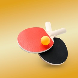 Image of Ping pong rackets and ball in air against orange gradient background
