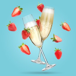 Image of Sparkling wine in flute glasses and fresh strawberries falling against light blue background