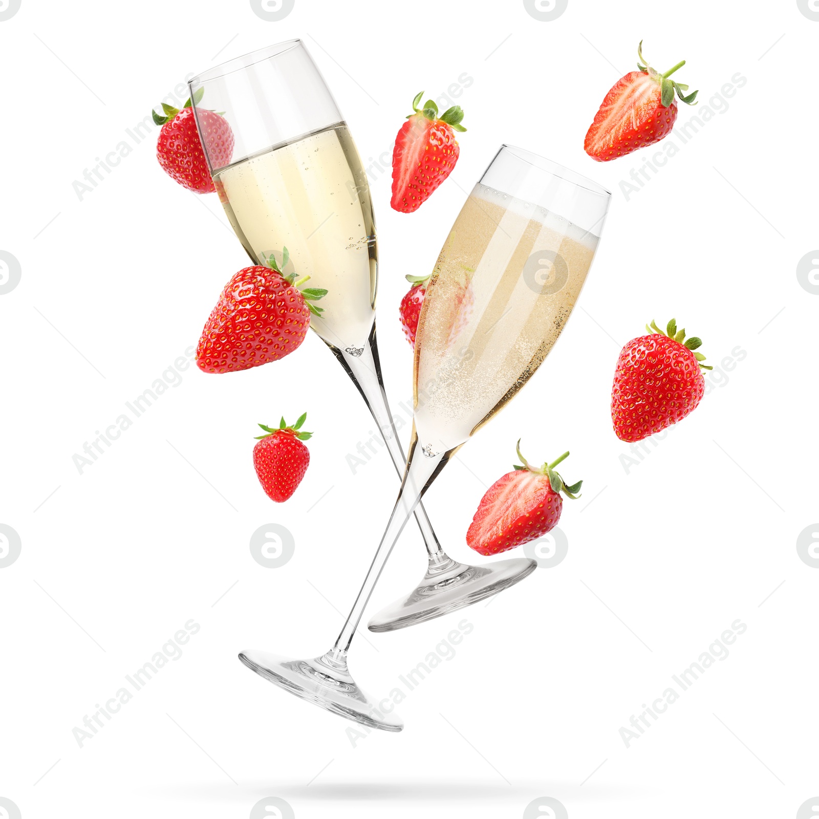 Sparkling wine in glasses and fresh strawberries falling against white background Image of Sparkling wine in glasses and fresh strawberries falling against white background