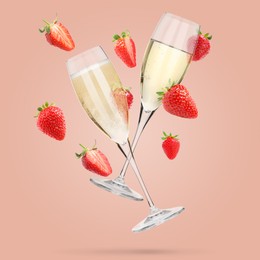 Image of Sparkling wine in glasses and fresh strawberries falling against pink background