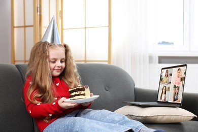 Image of Celebrating birthday online. Little girl with cake having video call with friends via laptop at home