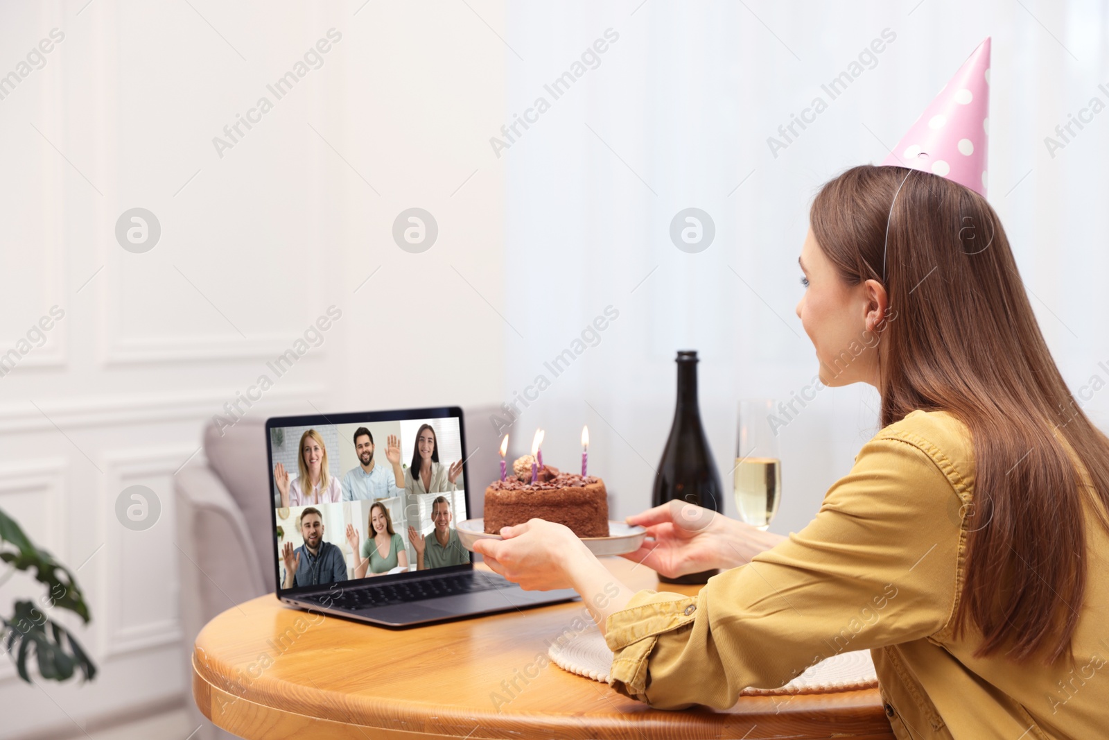 Celebrating birthday online. Woman with cake having video call with friends via laptop at home Image of Celebrating birthday online. Woman with cake having video call with friends via laptop at home
