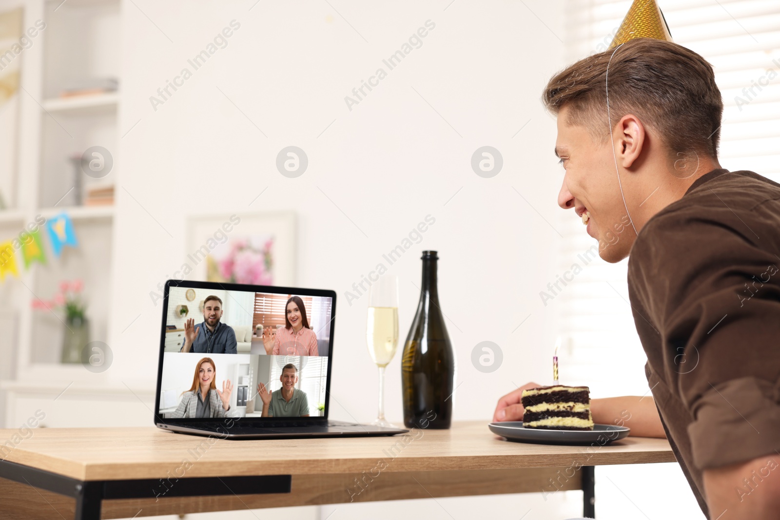 Celebrating birthday online. Man with cake having video call with friends via laptop at home Image of Celebrating birthday online. Man with cake having video call with friends via laptop at home