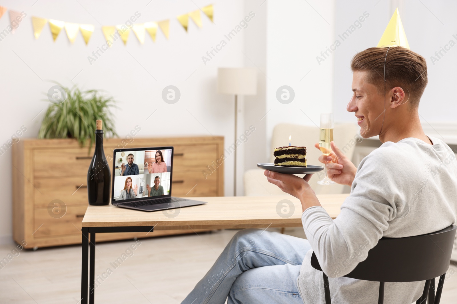 Celebrating birthday online. Man with sparkling wine and cake having video call with friends via laptop at home Image of Celebrating birthday online. Man with sparkling wine and cake having video call with friends via laptop at home