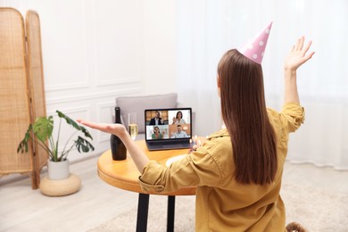 Image of Celebrating birthday online. Woman having video call with friends via laptop at home