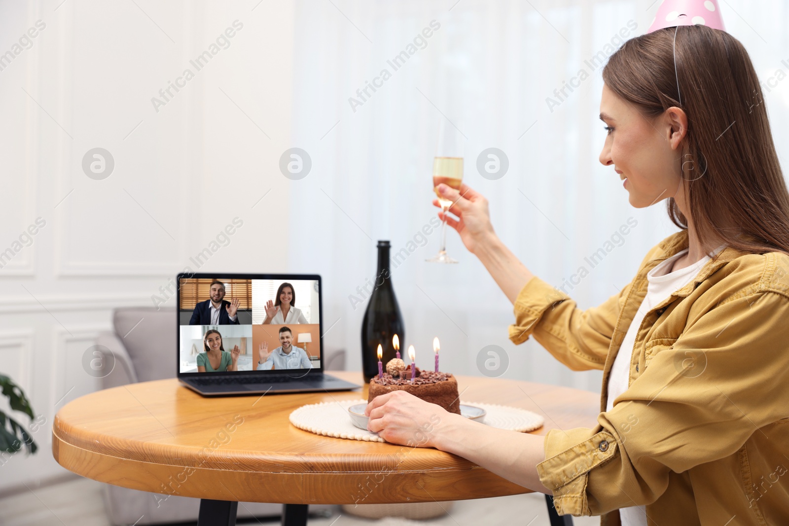 Celebrating birthday online. Woman with sparkling wine and cake having video call with friends via laptop at home Image of Celebrating birthday online. Woman with sparkling wine and cake having video call with friends via laptop at home