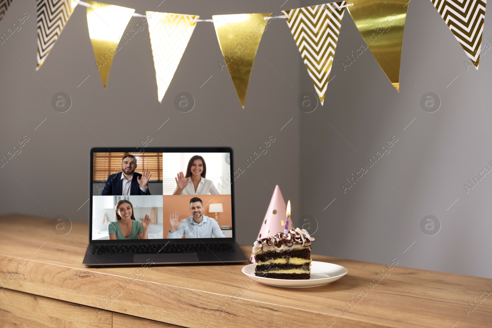 Celebrating birthday online. Video call with friends via laptop, cake and party hat on table indoors Image of Celebrating birthday online. Video call with friends via laptop, cake and party hat on table indoors