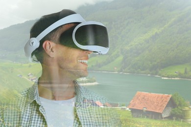 Image of Happy man using virtual reality headset, double exposure with mountain landscape