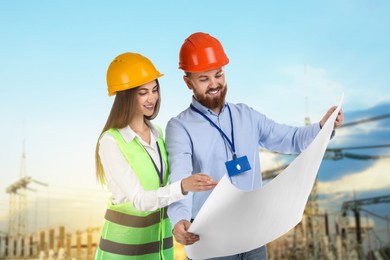 Image of Power engineers in hard hats with draft against electrical substation