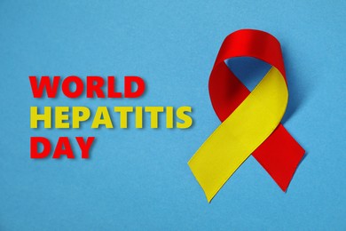 Image of 28th july World Hepatitis Day. Yellow-red awareness ribbon on light blue background, top view