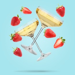 Image of Sparkling wine in glasses and fresh strawberries falling against light blue background