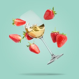 Image of Wine in glass and fresh strawberries falling against pastel turquoise background