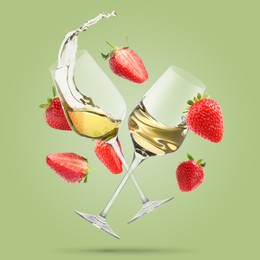 Image of Wine in glasses and fresh strawberries falling against pastel green background